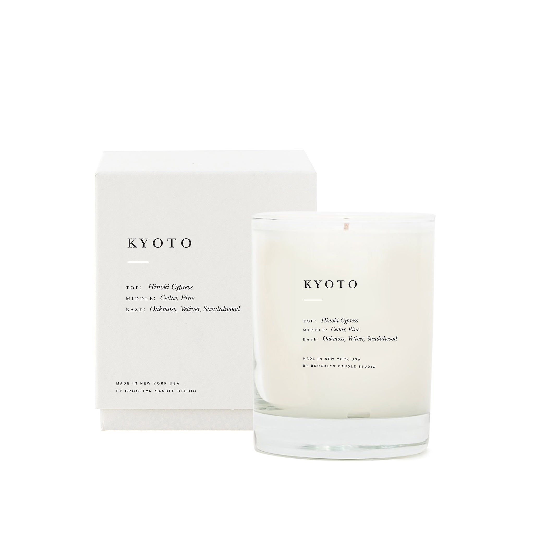Brooklyn Candle Studio scented candle Kyoto series Escapist with packaging. A romantic homage to Kyoto in the rain, green avenues and Japanese wooden architecture. This wonderful scented candle is a meditative, calming composition of Hinoki cypress, cedar, sandalwood, vetiver and pine. Hand-poured with 100% soy wax in the small manufactory of Brooklyn Candle Studio.